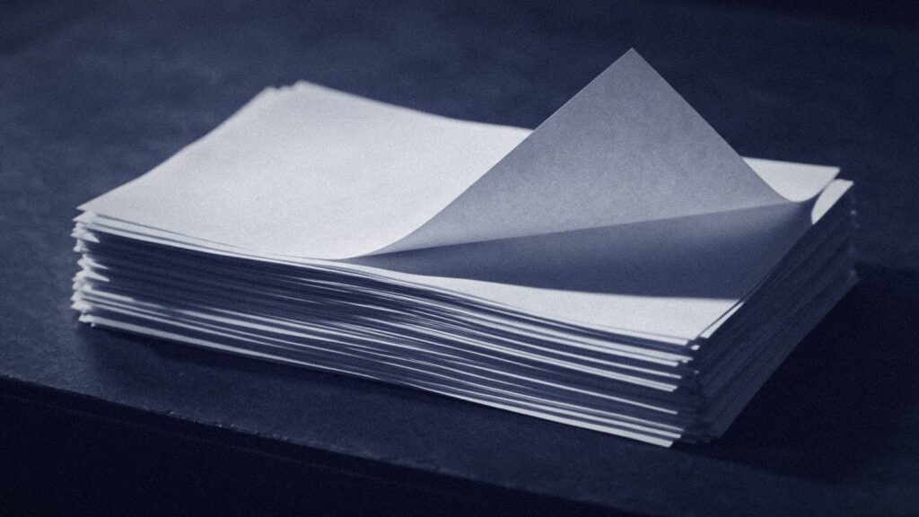 A Stack Of Identical Blank Sheets With One Lifted, Standing For Rates Repeated Without A Source