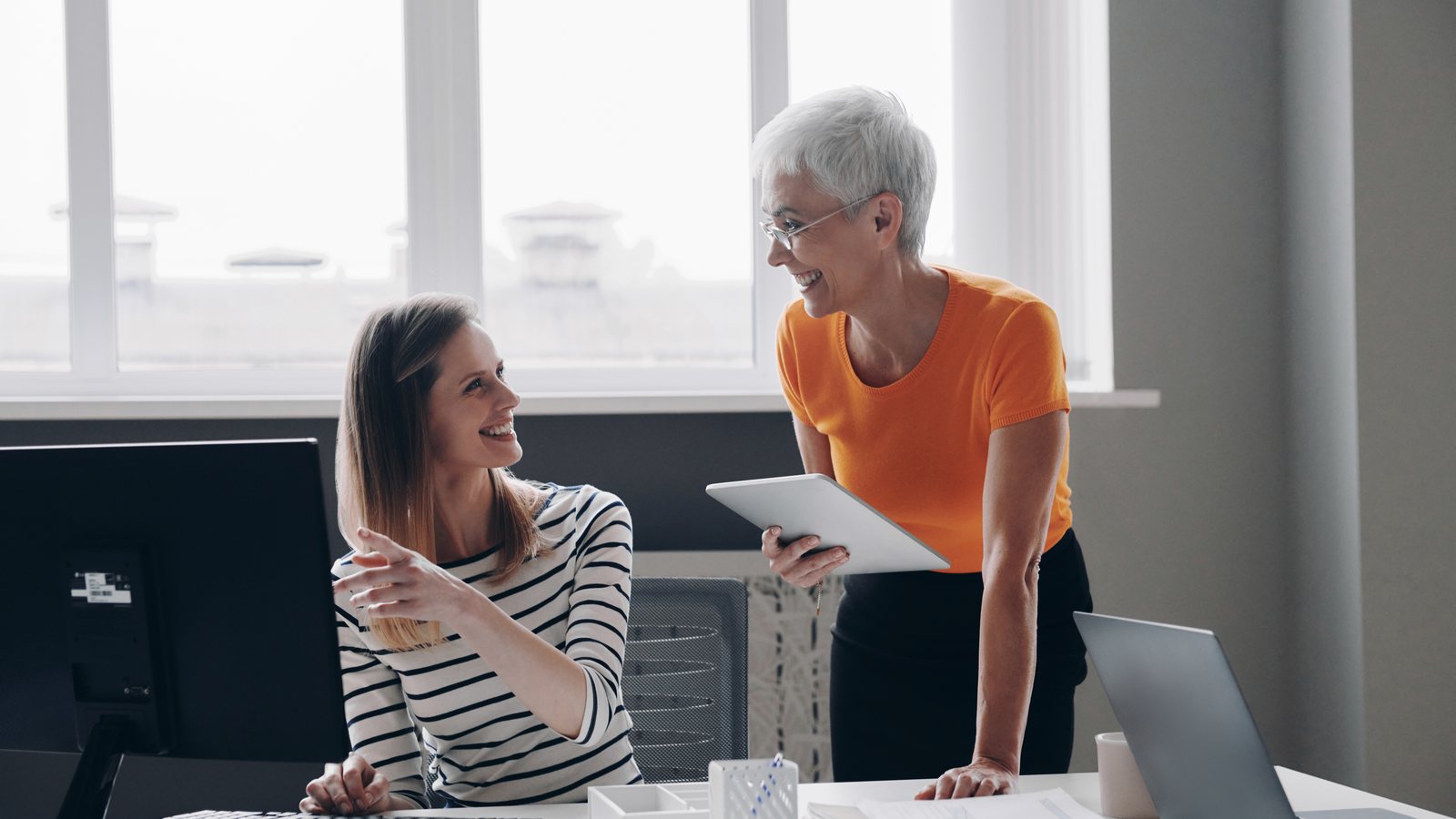 A Senior Colleague Coaching A Junior Team Member At A Desk, The Training Ground Ai Automation Puts At Risk.